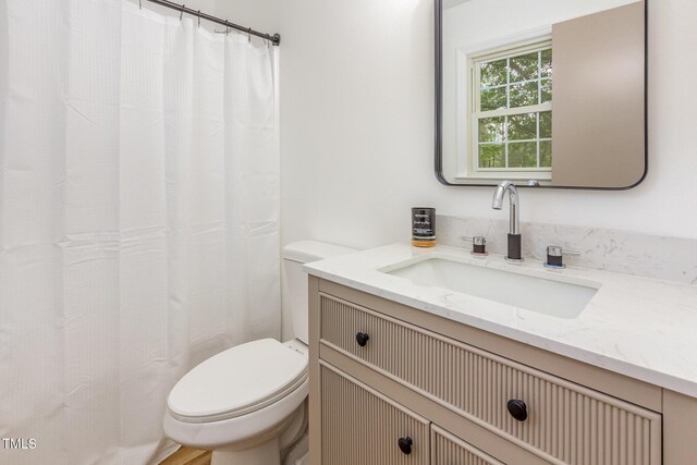 full bathroom with toilet, vanity, and curtained shower