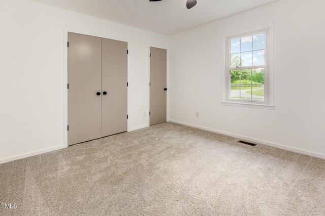 unfurnished bedroom with carpet floors, baseboards, ceiling fan, and a closet