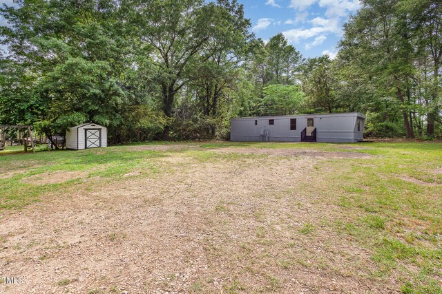 view of green lawn with a storage shed, an outbuilding, and entry steps