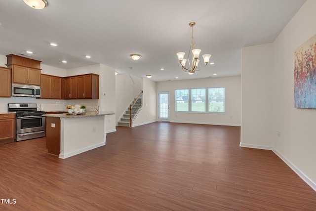 kitchen featuring stainless steel appliances, open floor plan, dark wood-type flooring, baseboards, and recessed lighting