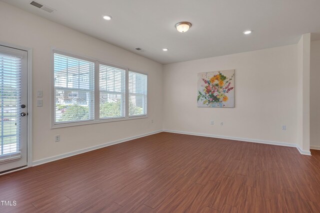 empty room featuring dark wood-style floors, healthy amount of natural light, baseboards, and recessed lighting