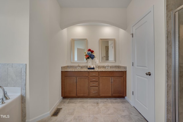 full bathroom with a bath, double vanity, tiled shower, and baseboards