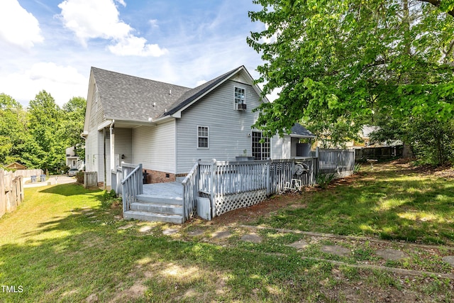 rear view of property featuring a shingled roof and a wooden deck