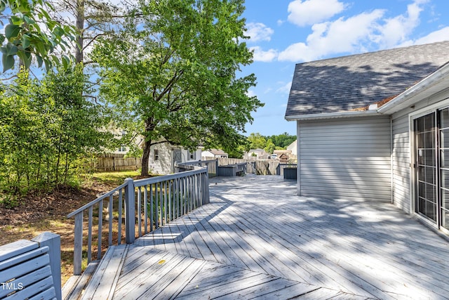 wooden deck featuring a shed, an outbuilding, and a fenced backyard