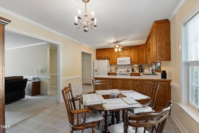 dining area with a chandelier, baseboards, a ceiling fan, and crown molding
