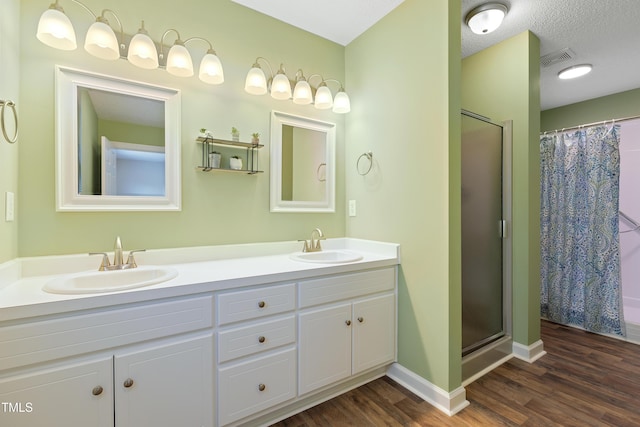 full bathroom with wood finished floors, curtained shower, double vanity, and baseboards
