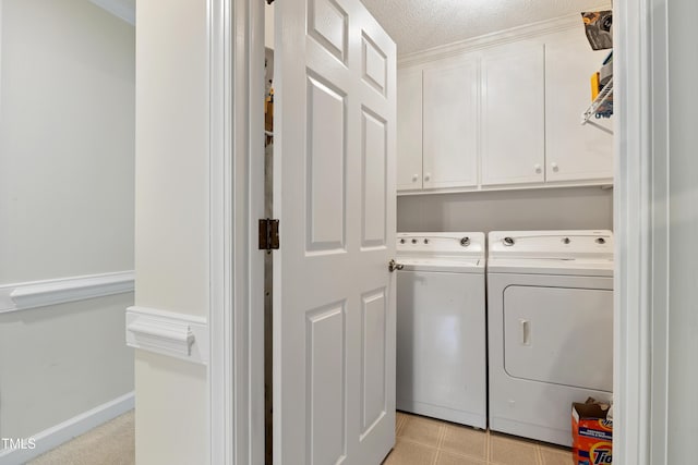 laundry area featuring washing machine and dryer, cabinet space, and a textured ceiling