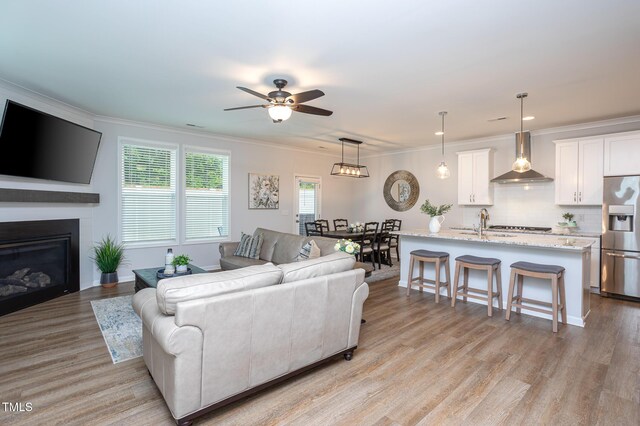 1048 Flagler St, Durham, NC 27713 - living area with a ceiling fan, light wood-style flooring, ornamental molding, a glass covered fireplace, and recessed lighting