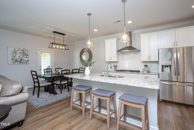 1048 Flagler St, Durham, NC 27713 - kitchen featuring stainless steel fridge with ice dispenser, a sink, wall chimney exhaust hood, light wood-style floors, and decorative backsplash
