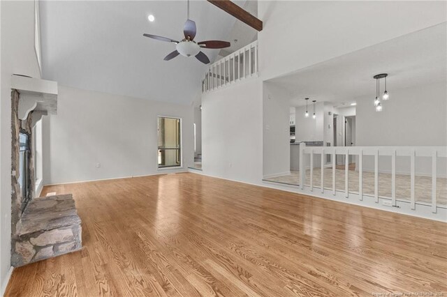 unfurnished living room with high vaulted ceiling, ceiling fan, and wood finished floors