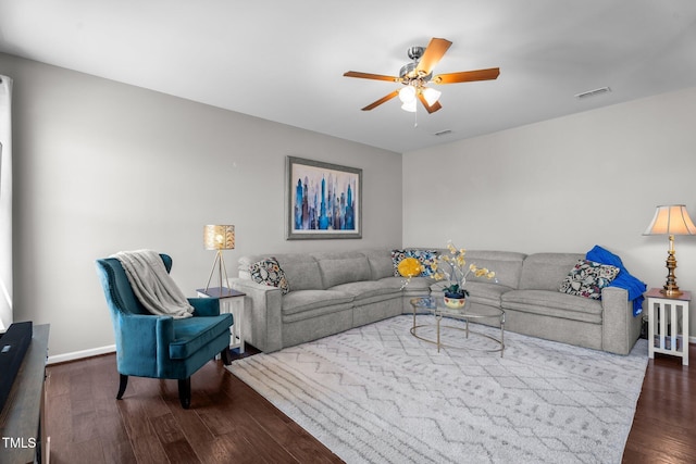 living room featuring ceiling fan, dark wood finished floors, and baseboards
