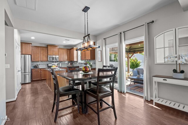 dining room featuring dark wood-style flooring, recessed lighting, baseboards, and a chandelier