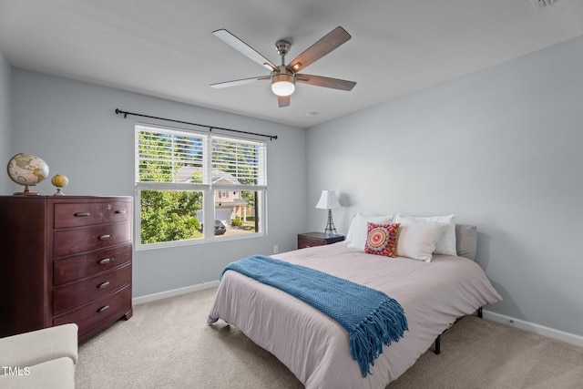 bedroom with light colored carpet, baseboards, and a ceiling fan