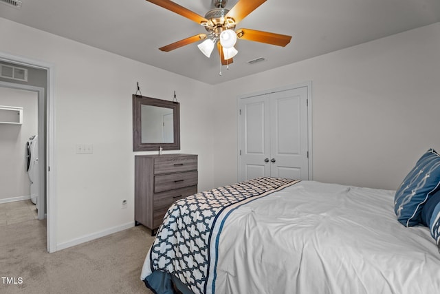 bedroom featuring light colored carpet, baseboards, a closet, a ceiling fan, and washer / dryer