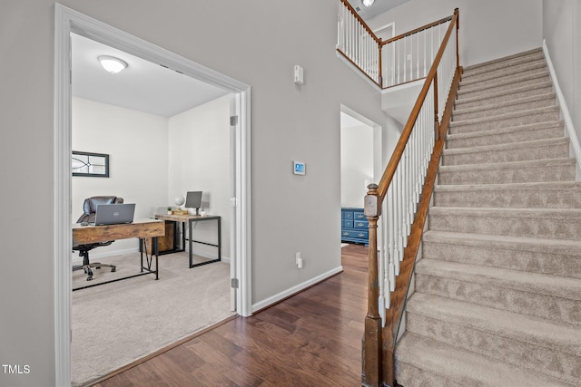stairway with wood finished floors and baseboards