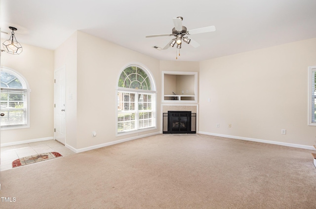 2111 Piney Brook Rd Unit 101, Raleigh, NC 27614 - unfurnished living room featuring light carpet, plenty of natural light, a tile fireplace, and ceiling fan