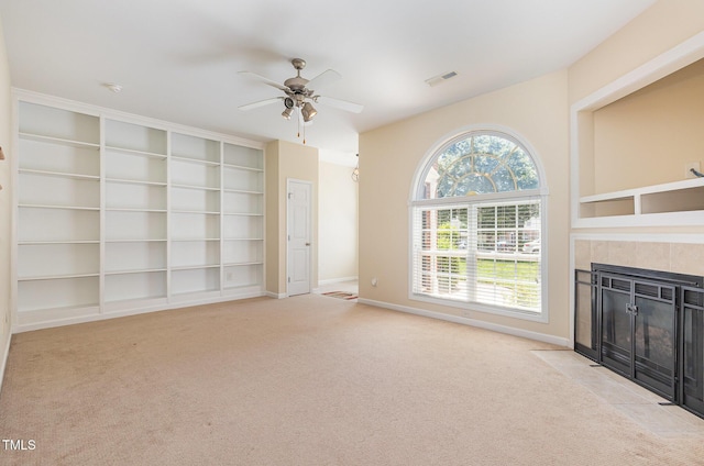 2111 Piney Brook Rd Unit 101, Raleigh, NC 27614 - unfurnished living room featuring carpet floors, ceiling fan, a tiled fireplace, and built in shelves