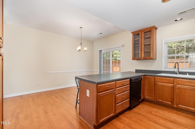 2111 Piney Brook Rd Unit 101, Raleigh, NC 27614 - kitchen with dishwasher, brown cabinetry, light wood finished floors, a peninsula, and dark countertops