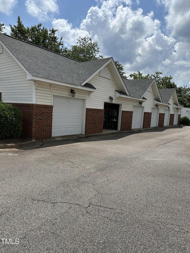 2111 Piney Brook Rd Unit 101, Raleigh, NC 27614 - view of front of property with brick siding, roof with shingles, an attached garage, and driveway