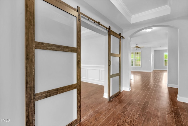 2808 Sand Trap Ln, Hope Mills, NC 28348 - hall with a barn door, arched walkways, dark wood-style flooring, ornamental molding, and a tray ceiling