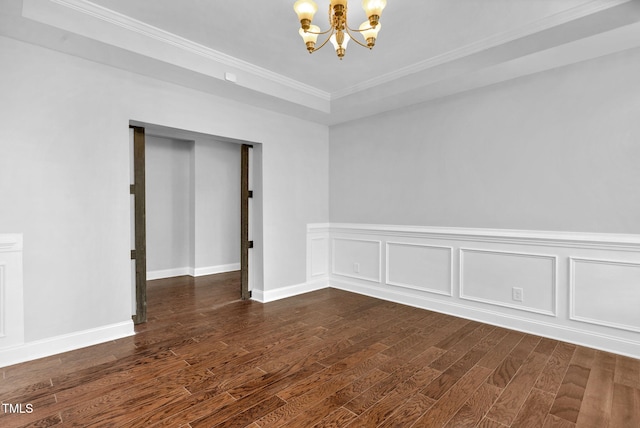 2808 Sand Trap Ln, Hope Mills, NC 28348 - spare room featuring a chandelier, dark wood-type flooring, ornamental molding, a tray ceiling, and baseboards
