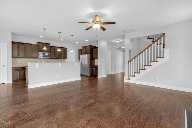 2808 Sand Trap Ln, Hope Mills, NC 28348 - unfurnished living room featuring ceiling fan, arched walkways, dark wood-style flooring, stairs, and baseboards
