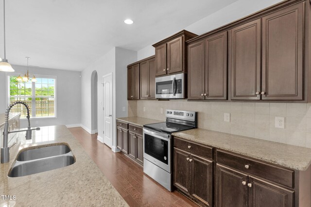 2808 Sand Trap Ln, Hope Mills, NC 28348 - kitchen featuring appliances with stainless steel finishes, a sink, dark wood finished floors, arched walkways, and decorative backsplash