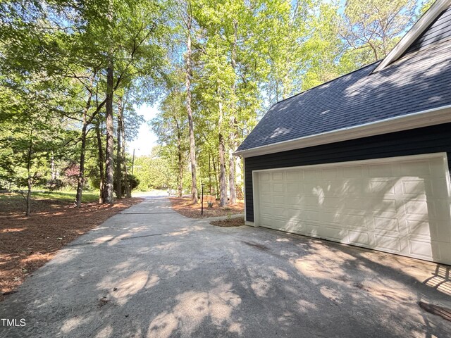 view of home's exterior with roof with shingles and a garage