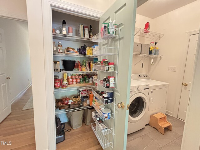 laundry room featuring separate washer and dryer and wood finished floors