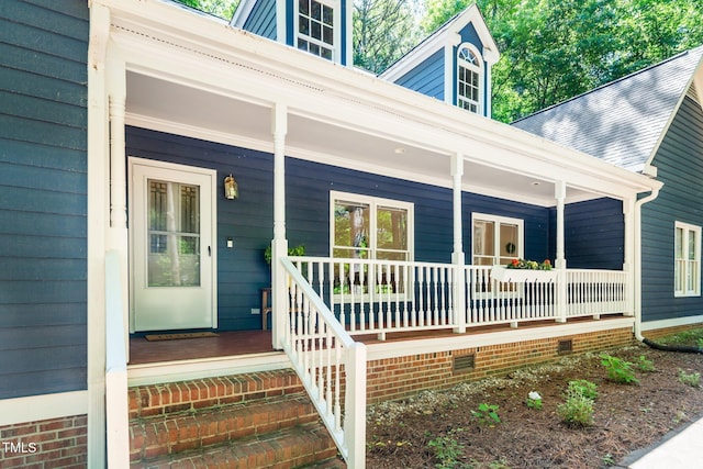 view of exterior entry featuring a porch and crawl space