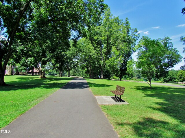 view of home's community featuring a lawn and view of scattered trees