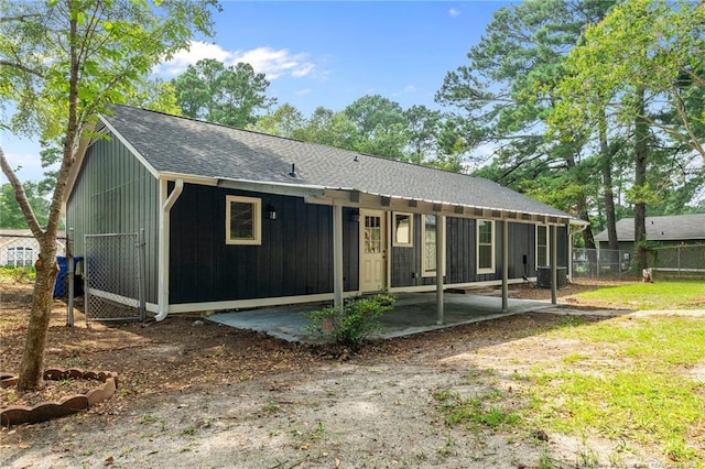 back of house with fence, a patio area, cooling unit, and roof with shingles