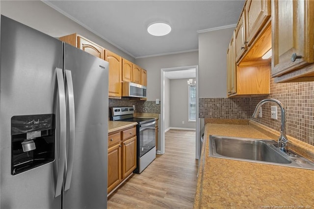 kitchen with appliances with stainless steel finishes, a sink, ornamental molding, backsplash, and light wood finished floors