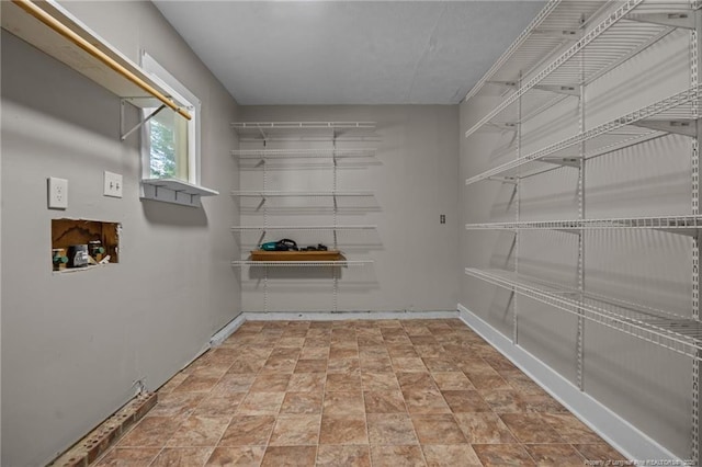 spacious closet featuring stone finish floors
