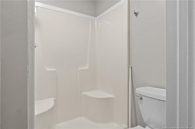 bathroom featuring a shower and toilet