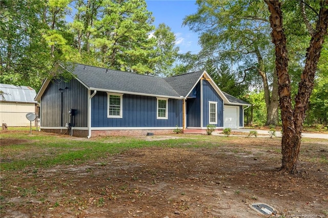ranch-style home with board and batten siding, roof with shingles, and a garage