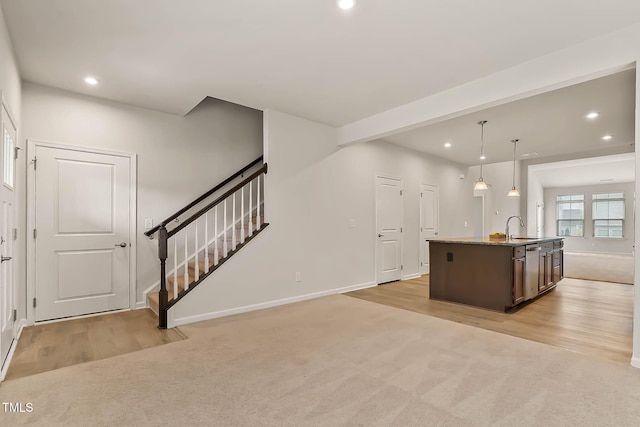 1745 Ripley Woods St, Wake Forest, NC 27587 - kitchen with recessed lighting, light carpet, an island with sink, light wood finished floors, and dark brown cabinets