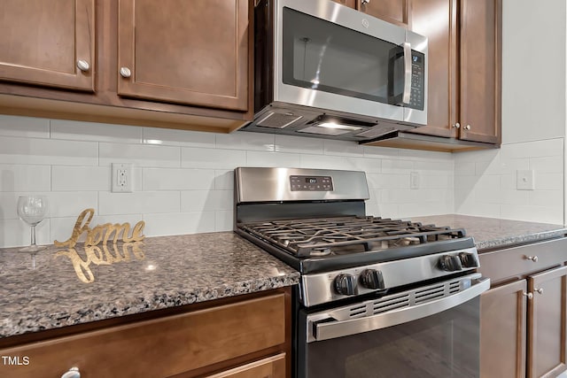 1745 Ripley Woods St, Wake Forest, NC 27587 - kitchen with appliances with stainless steel finishes, backsplash, and dark stone counters