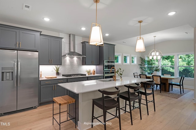 1913 Ballard Rd Unit 193, Fuquay Varina, NC 27526 - kitchen featuring stainless steel appliances, wall chimney range hood, light countertops, a breakfast bar, and vaulted ceiling