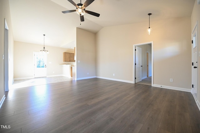 unfurnished living room with vaulted ceiling, a ceiling fan, dark wood-style flooring, and baseboards