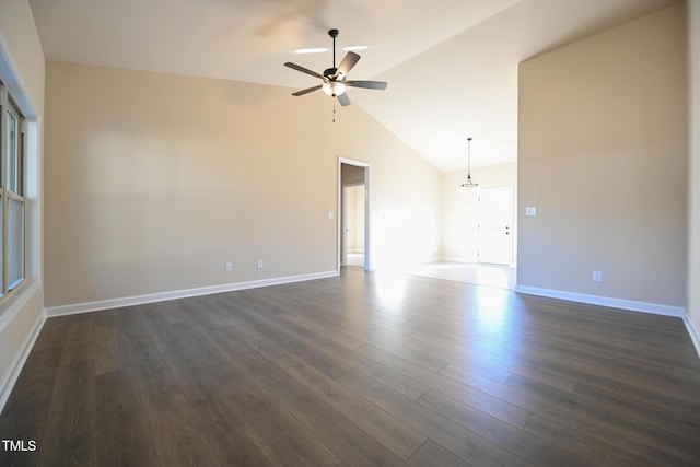 spare room with a ceiling fan, lofted ceiling, dark wood-style flooring, and baseboards