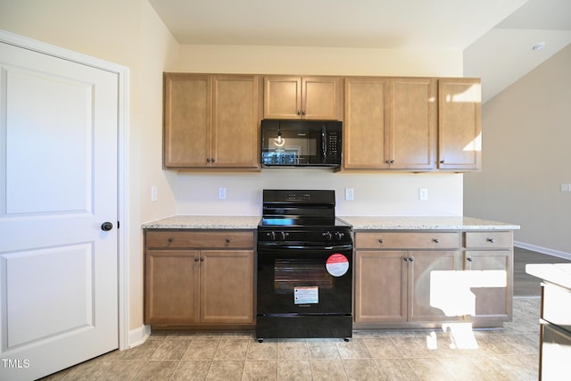 kitchen featuring black appliances, light stone counters, and baseboards
