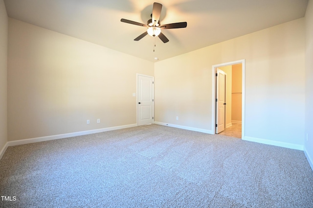 spare room with a ceiling fan, light colored carpet, and baseboards