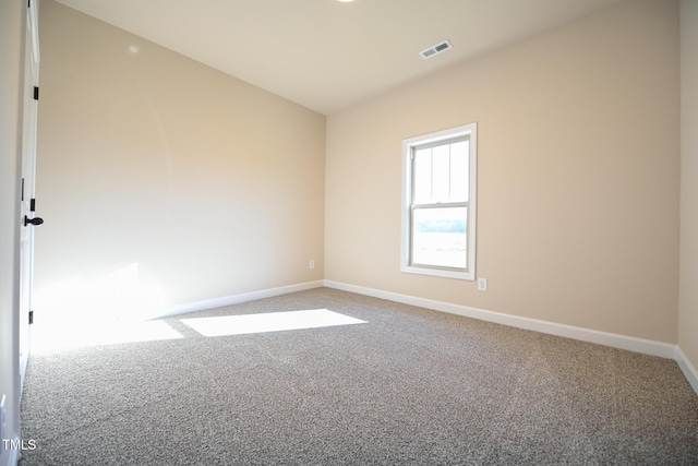 carpeted empty room featuring baseboards and lofted ceiling