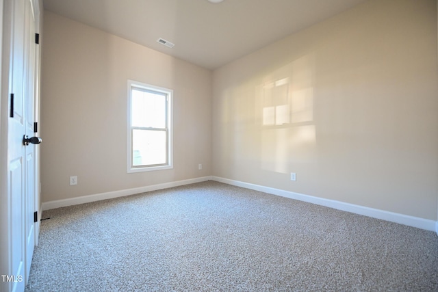 spare room featuring carpet and baseboards