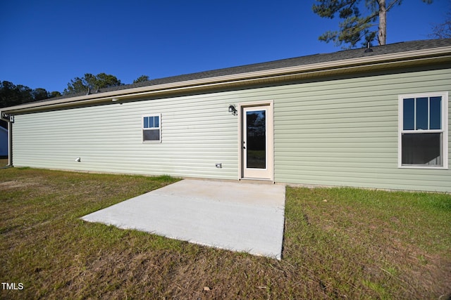 rear view of property featuring a patio area and a lawn