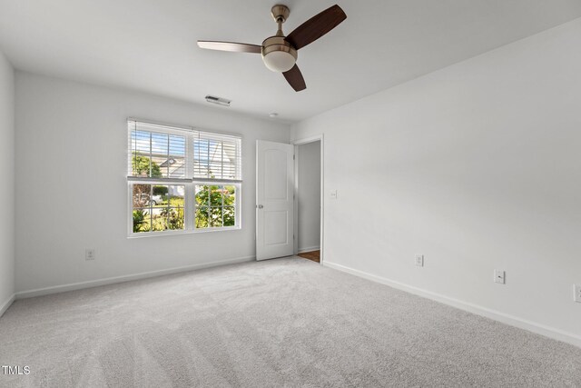 carpeted empty room with ceiling fan and baseboards