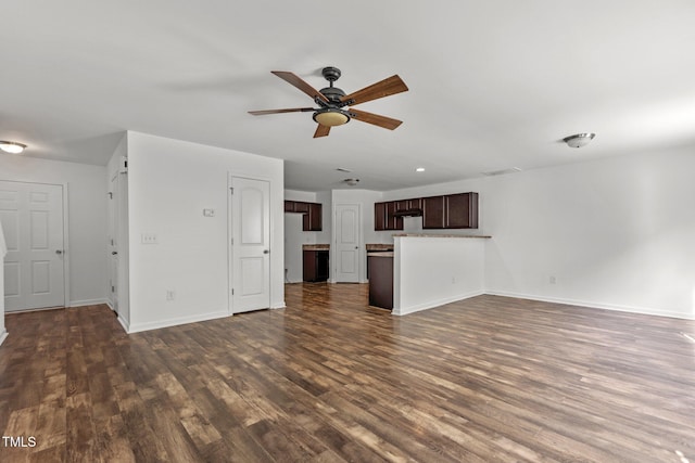 unfurnished living room with ceiling fan, dark wood-type flooring, and baseboards
