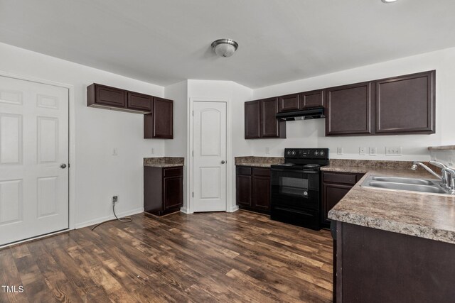 kitchen with black electric range oven, under cabinet range hood, a sink, dark brown cabinetry, and dark wood-style floors