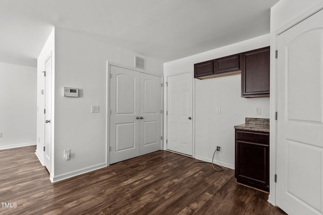 interior space featuring dark wood-type flooring and baseboards